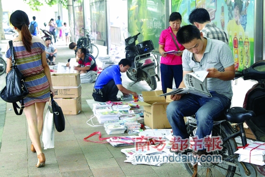 7月18日，市民在郑州街头的一个报摊前挑选报纸。C FP图片