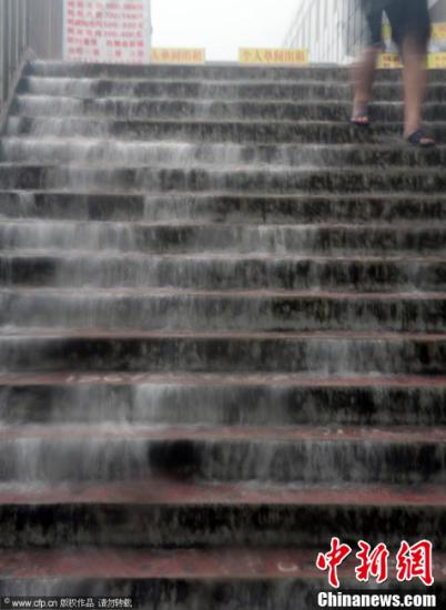 2012年7月21日，北京突降暴雨。图为一处阶梯水流如柱。鲜康 杨登峰 摄 CFP视觉中国