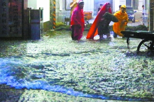 北京暴雨不眠夜警民同救灾 居民用沙袋防水自