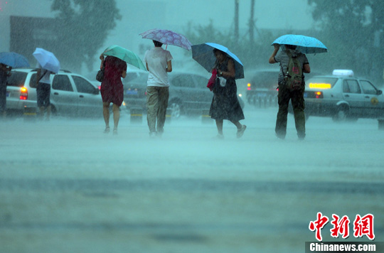 7月22日，辽宁沈阳遭遇强降雨，市民在雨中艰难行走。中新社发 于海洋 摄