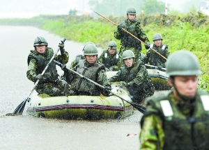 2012年7月15日，日本九州岛遭受暴雨袭击，日本自卫队成员搜索失踪人员。