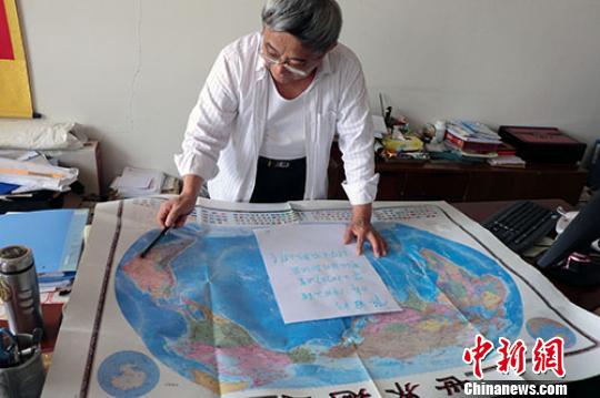 60岁刘庆祥在地图上看着陈冠明要走的国家邵国栋摄