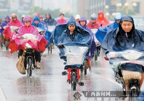 受台风影响，7月24日下午南宁市下起大雨。图为顶风冒雨回家的市民。记者 徐天保 摄