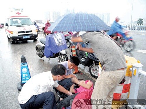 南宁:女子骑电单车摔伤躺雨中 热心市民帮撑伞