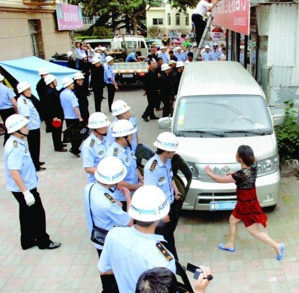 青岛彪悍女挥斧头菜刀阻强拆 城管站一排举盾牌(图)