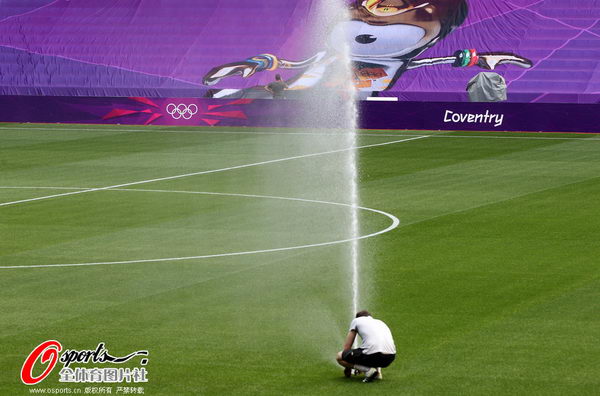 图文:女子足球比赛上演 工作人员撒水中