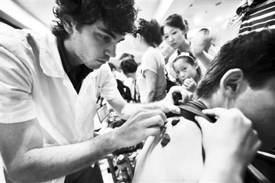2010年7月19日，杭州，澳大利亚籍留学生安德雷在为市民进行“冬病夏治”诊疗。