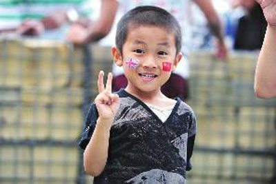 7月28日,奥林匹克公园外,一个中国小男孩在脸上绘上中英两国国旗 摄友