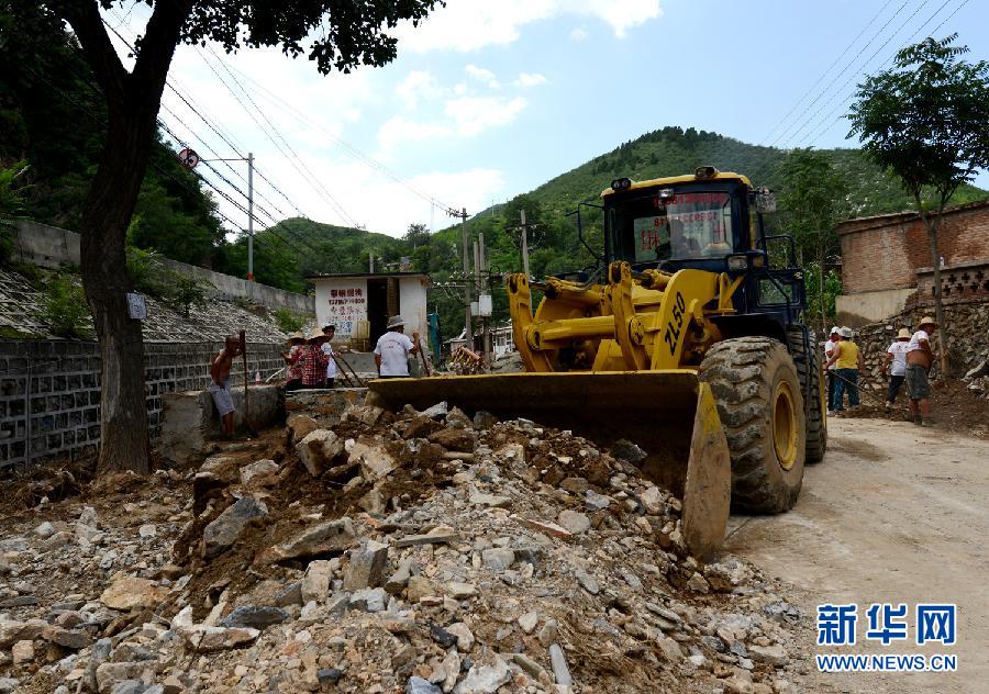 7月29日,一辆推土机在市房山区青龙湖镇北车营村清理碎石.