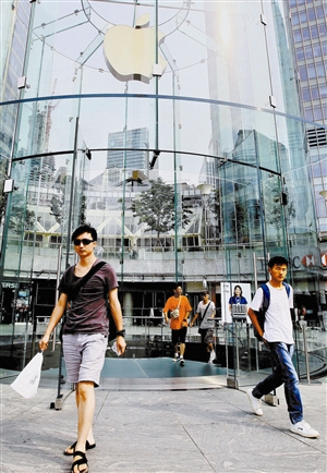 一些顾客从上海陆家嘴地区的苹果手机专卖店前走过。新华社发