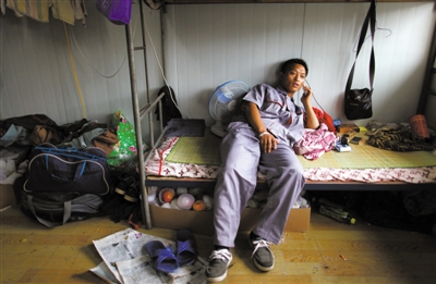 7月31日，京港澳高速旁河西再生水厂建筑工地，李川南躺在床上打电话。床下，放着慰问者送来的水果。本版摄影/新京报记者 薛珺