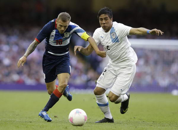 奥运图:足球赛英国胜乌拉圭 争抢球