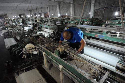 回龙坝一家织布厂处于半停产状态,偌大的厂房内只有一名机修工在维修