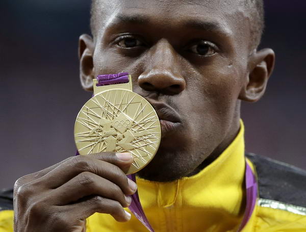 奥运图:博尔特获颁百米金牌 亲吻金牌