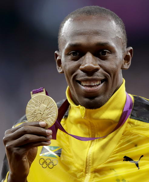 奥运图:博尔特获颁百米金牌 哂金牌