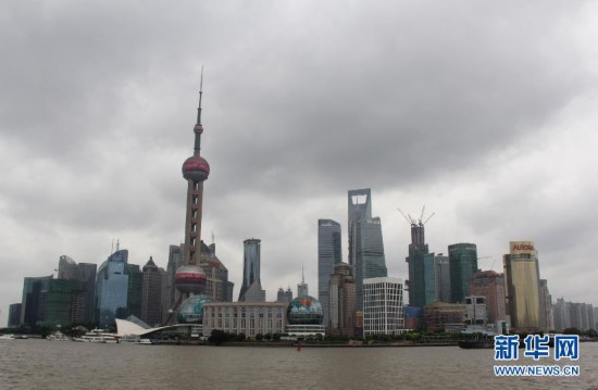 8月7日拍摄的上海东方明珠塔下，国旗在强劲的风中飘扬。