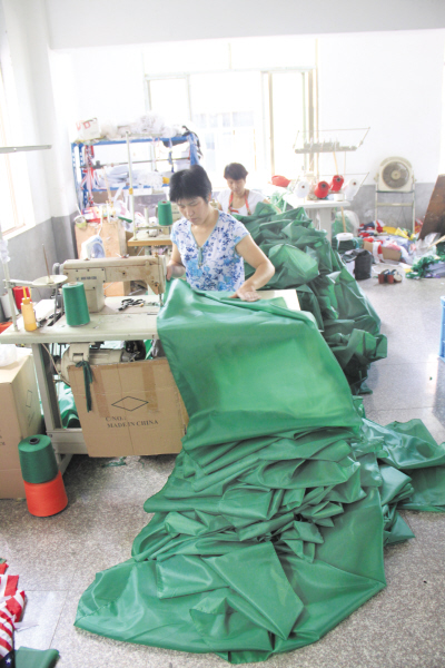 在前仓一些外贸加工企业里，原先看到的产品主角“米字旗”，如今已变成了清一色的绿头巾。图为工人们正在赶制发往中东地区的传统服饰绿头巾。
