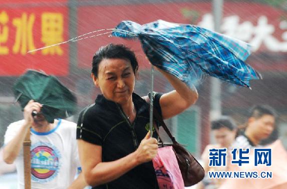 2012年8月8日 “海葵”减弱为强热带风暴 对上海影响仍将持续3天。行人顶着风雨在上海徐汇区宜山路街头行走。