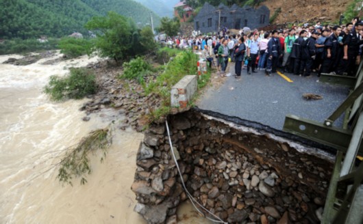 8月9日，在安吉县报福镇，被困游客排队等待通过新架设的桥梁。 新华社 图
