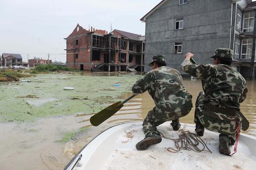 8月10日，武警湖州支队的战士在被大水淹没的吴山村搜寻需要转移的群众。新华社记者 徐昱 摄