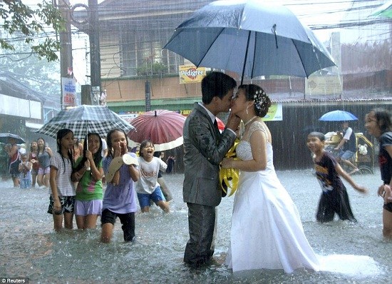 菲律宾首都马尼拉街头，一对新人在及膝的洪水中举行婚礼