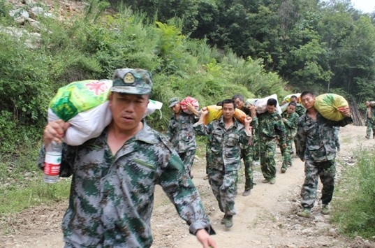 图为民兵应急分队正在抢运蔬菜等生活必需物资