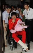 图文：刘翔出现在浦东机场 轮椅上捧花面对镜头