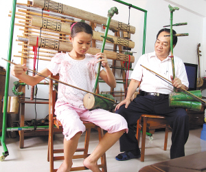 八月十三日，黄照安教授小学徒演奏黎族竹木乐器。 特约记者 黄青文 摄