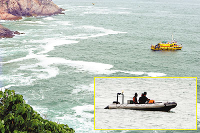钓鱼客在大坳门堕海失踪，现场海面风浪颇大。(小图)消防员以橡皮艇载同其中一名事主(后)在现场附近搜寻失踪者。香港文汇报