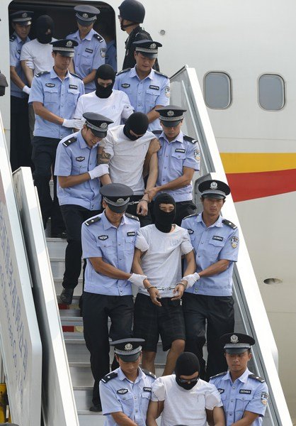 8月25日,在北京首都国际机场,涉案犯罪嫌疑人被押解下飞机.