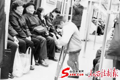 在上海地铁一号线上,肢体有残疾的孩子在乞讨.