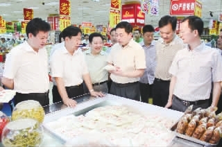 株洲市委常委、常务副市长、市食品平安委员会常务副主任王志刚（中）在现场突击反省米粉市场。