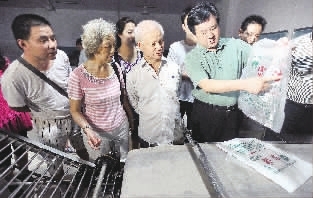 株洲市政府副秘书长、市食安办主任李能斌（右）正在向消耗者代表示场先容食品消耗情况。