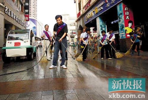 荔湾区上下九广场，市人大常委会主任张桂芳和机关干部一起清扫街道。