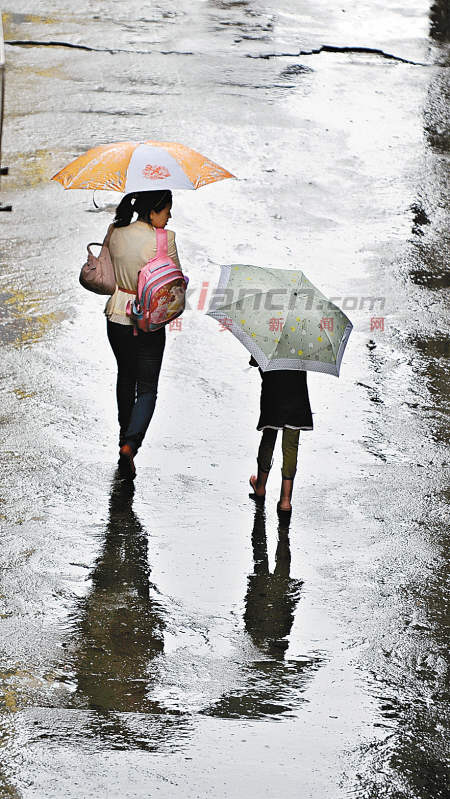 昨日,中小学开学第一天,清晨7点半左右,一位母亲冒雨送孩子上学.