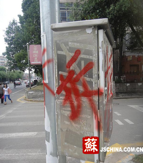 南京一治安警灯柱遭恶搞 被人用红字写10个拆