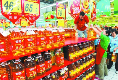 青岛一家超市的工作人员在摆放食用油(图)