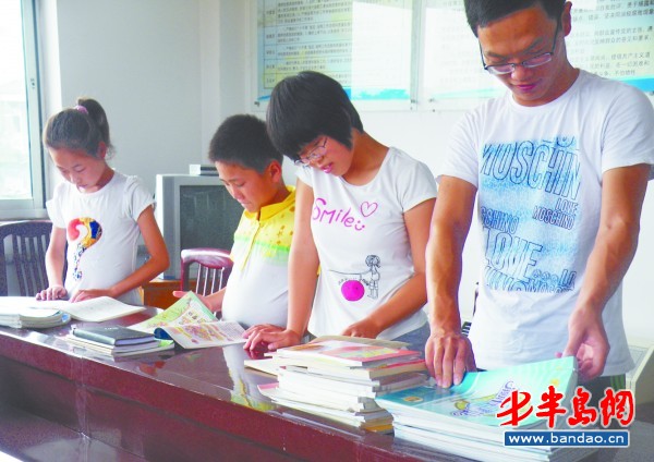 学生们正在翻看工作人员为他们买的学习用品。