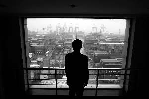 2011年1月19日,上海,一名港口员工望着办公室窗外的集装箱.