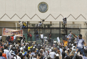 13日，在也门首都萨那，抗议示威人群爬上美国驻也门大使馆的铁门