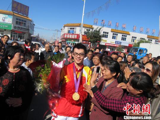 15日，2012年伦敦残奥会乒乓球TT8级男子单打冠军赵帅回到家乡河北省张家口市蔚县，前来欢迎的乡亲们挤满了街道。谭地摄