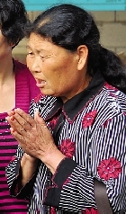 纪永锋的母亲双手合十为儿子祈祷。