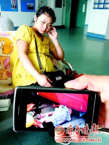 胡先生被压在车轮下,怀有7个月身孕的杜女士等在监护室外面一脸愁容。本报记者王倩摄