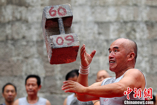 10月5日，江苏南京的一群民间大力士齐聚中华门城堡内，现场掷起数十斤至一百多斤不等的石锁，一展力量与技艺。中新社发 泱波 摄