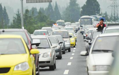 10月2日,都汶高速堵车,图为一市民身体探出车外打电话.董睿摄