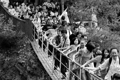 10月3日，在黄陂木兰天池景区，蜂拥而来的游客挤满景区每条道路和景点。图为拉索桥上的游客排成密集队形通过。