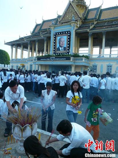 10月17日，柬埔寨前国王诺罗敦・西哈努克的灵柩由北京运抵金边。图为柬埔寨民众在迎候灵柩。中新社发 王雪 摄