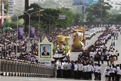 昨日，在柬埔寨首都金边，民众目送柬埔寨太皇西哈努克的灵柩从机场前往王宫。 新华社发