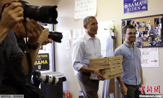 当地时间10月14日，美国弗吉尼亚州威廉斯堡，美国总统大选“激战正酣”，现任美国总统奥巴马化身“送餐员”，手捧披萨饼来到自己的竞选办公室，慰劳竞选团队的志愿者们。