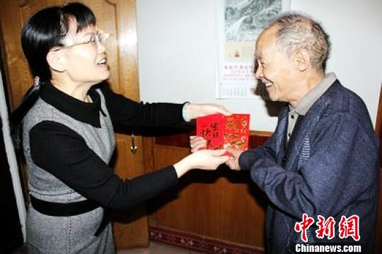 娄底市侨联主席向国蓉为老归侨送上慰问金。
